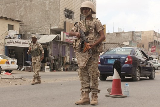 Loyalist forces stand guard on a main road in the Mansura residential district of Aden after they pushed Al Qaeda out of parts of the southern city yesterday in a new drive against the militants.