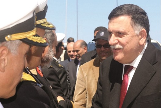Libyan prime minister-designate Fayez al-Sarraj (right) is greeted upon arrival in Tripoli, Libya yesterday.