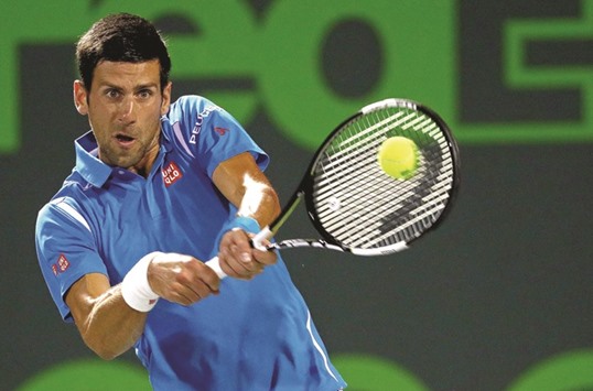 Novak Djokovic of Serbia hits a backhand against Tomas Berdych of the Czech Republic during Day 10 of the Miami Open at Crandon Park Tennis Center in Miami on Wednesday.