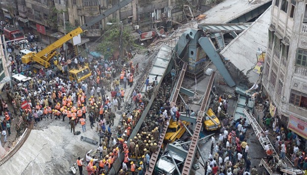 Rescue workers and volunteers try to free people trapped under the wreckage of the collapsed flyover bridge in Kolkata yesterday.