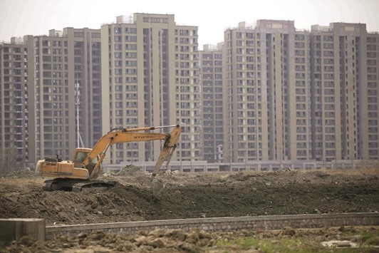 An excavator is seen at a construction site of new residential buildings in Shanghai. The economic and financial risks to the Chinese governmentu2019s creditworthiness are gradually increasing, S&P said in a statement yesterday.