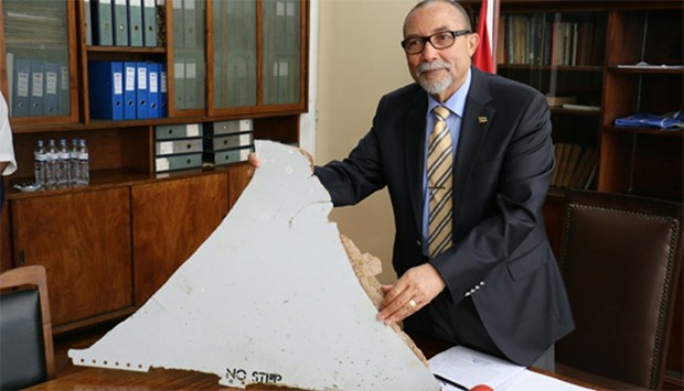 The head of Mozambique's Civil Aviation Institute, Comandante Joao Abreu, shows a piece of debris fo