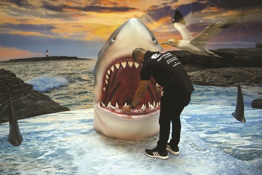 A man looks at a 3D shark display at the Dubai Mall.