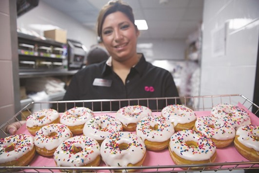 A worker displays fresh donuts during the opening of a Dunkinu2019 Donuts restaurant in Mexico City. The Massachusetts based company added 55 Dunkinu2019 Donuts franchise stores across Europe in 2015, bringing the total there to 221.