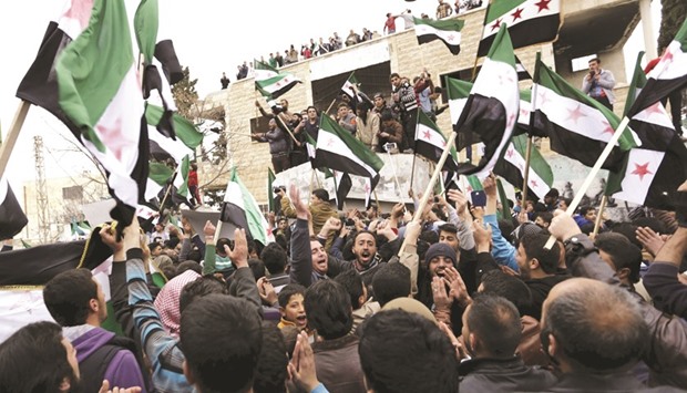 Protesters carry Free Syrian Army flags and chant slogans during an anti-government protest in the town of Marat Numan in Idlib province, Syria, yesterday.