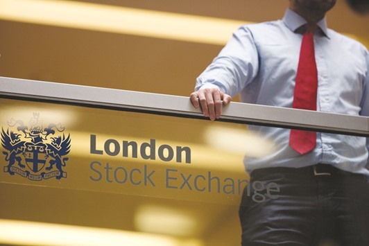 An employee leans on a glass wall above the main atrium of the London Stock Exchange Group headquarters. The FTSE 100 closed 1% up at 6,191.96 points yesterday.