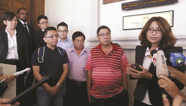Lawyer Sangeet Deo speaks to members of the media, accompanied by relatives of passengers Tan Ah Meng, his wife Chuang Hsiu Ling, and son Tan Wei Chew, who were aboard the missing Malaysia Airlines flight MH370, during a hearing for the compensation suit brought against the Malaysian government and Malaysia Airlines over claims of negligence and breach of trust, in Kuala Lumpur.