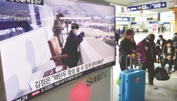 Travellers walk past a public television screen showing file footage of North Korean leader Kim Jong-Un, at a railway station in Seoul yesterday. Kim has ordered its nuclear arsenal readied for pre-emptive use at any time, in an expected ramping up of rhetoric following the UN Security Councilu2019s adoption of tough new sanctions on Pyongyang.