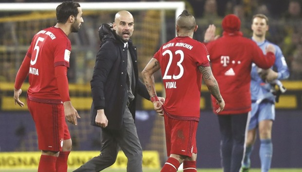 Bayern Munich coach Pep Guardiola discusses with Medhi Benatia and Arturo Vidal after the goalless draw against Borussia Dortmund. (Reuters)