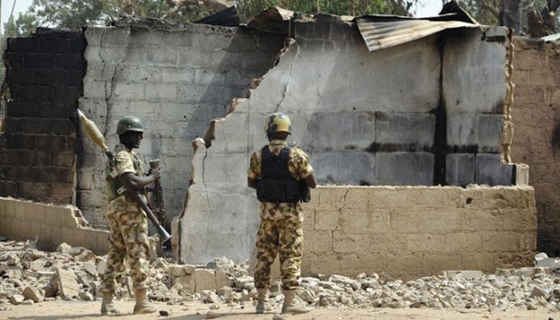 Soldiers looks at burnt houses in the village of Dalori, some 12km from Borno state capital Maiduguri, northeastern Nigeria.