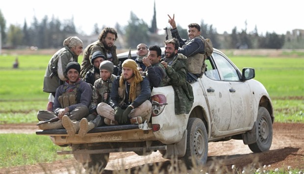 Rebel fighters from 'Jaysh al-Sunna' gesture as they ride a vehicle in Tel Mamo village, in the southern countryside of Aleppo, Syria yesterday. AFP