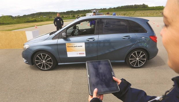 A BMW car is parked via a mobile device remote control during a parking assist app demonstration at the Robert Bosch driverless technology press event in Boxberg, Germany, on May 19, 2015. u201cIn the future, u2018Sheer Driving Pleasureu2019 will also be defined as liberating drivers through automation,u201d BMW said yesterday in a statement as it celebrated turning 100 years old.