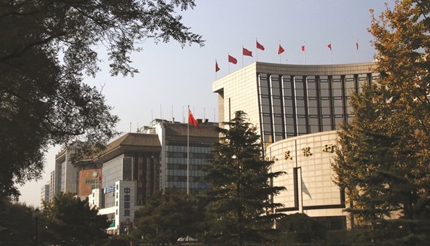 The Peopleu2019s Bank of China headquarters (right) is seen in Beijing. Chinau2019s foreign-exchange reserves, the worldu2019s largest currency hoard, dropped by $28.6bn to $3.2tn in February, the PBoC said in a statement yesterday.