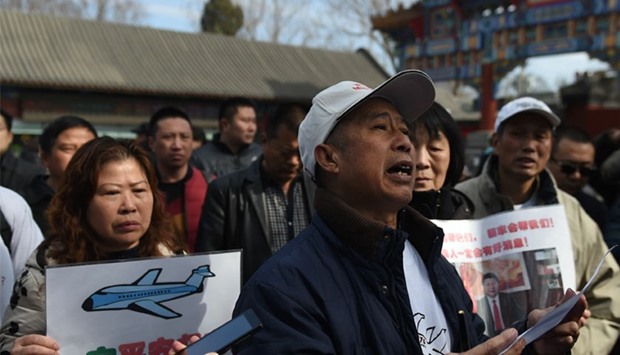 A relative of passengers missing on Malaysia Airlines MH370, reads a statement to journalists during a gathering of relatives outside the Lama Temple in Beijing today.