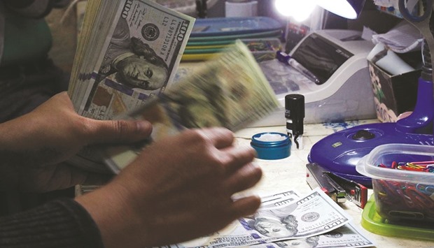 A money changer counts the US dollar bills at a currency exchange in Manila. The dollaru2019s ascent in 2015 was the steepest since 1997. The spread between the weakest and strongest appreciation among the US states was 11 points, the widest since 2008.