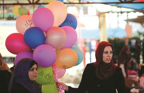 Palestinian women hold balloons, some reading in Arabic u2018womenu2019s rightsu2019, during an event organised by the UN to mark International Womenu2019s Day at a park in Gaza City yesterday.