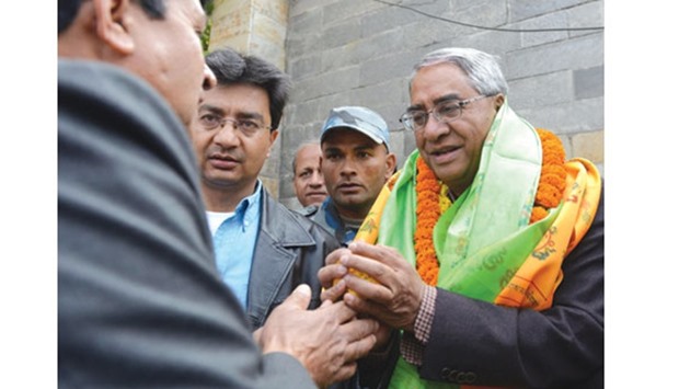 Sher Bahadur Deuba, right, the newly elected president of Nepali Congress, is congratulated by supporters at his residence in Kathmandu yesterday.