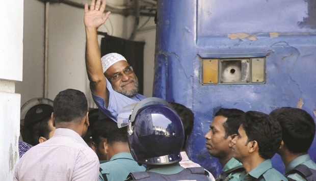 In this file photo, Mir Quasem Ali waving his hand as he enters a van at the ICT court in Dhaka.