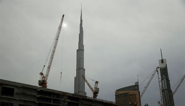 Cranes tower over a construction site as the Burj Khalifa, the tallest building in the world, is seen in Dubai. Reuters