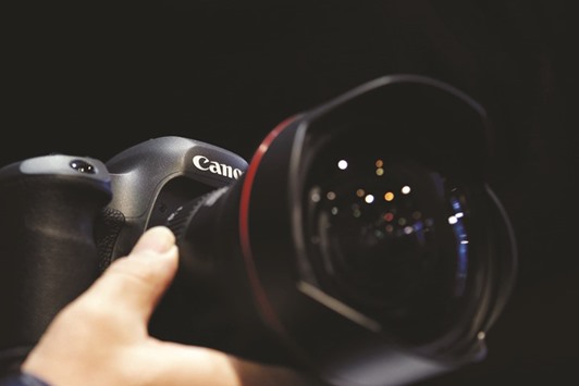 An attendee tries out a Canon EOS-5Ds digital single lens reflex (DSLR) camera. The firm had won prime position to take Toshiba Medical Systems, not only because its bid topped u00a5700bn ($6.2bn), but also because there was little overlap between the two firmu2019s medical equipment businesses, raising few anti-trust concerns, the Nikkei business daily said yesterday.