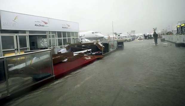 People run for cover during a rainstorm in Al Bateen airport in Abu Dhabi on Wednesday