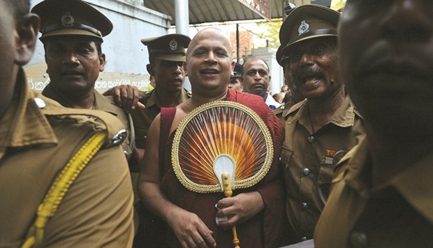 Prison guards escort Buddhist monk Uduwe Dhammaloka, centre, to the main jail in Colombo yesterday, after a magistrate ordered he be remanded in custody till March 17 for keeping a baby elephant without a licence.