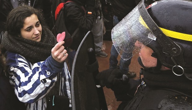 A student offers a heart-shaped paper cutout to a French riot police officer during a demonstration against the labour law proposal in Lyon, France, as part of nationwide labour reform bill protests by students and union members.
