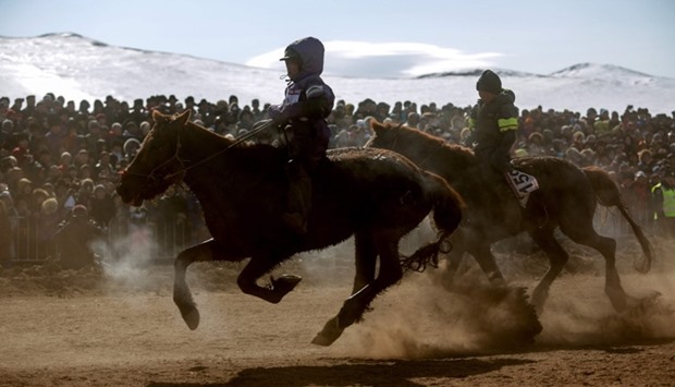 This picture taken on March 5, 2017 shows Mongolian child jockeys competing in the ,Dunjingarav 2017, spring horse race on the outskirts of Ulan Bator.
