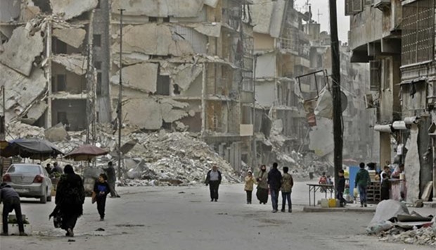 Syrians walk in the once rebel-held al-Shaar neighbourhood in the northern city of Aleppo on Friday.