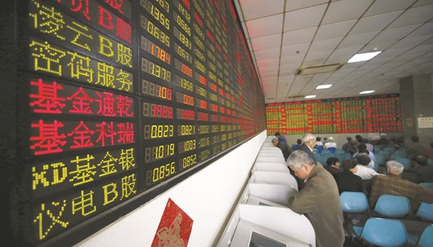 Investors look at computer screens showing stock information at a brokerage house in Shanghai. The Shanghai Composite Indexu2019s 2017 gains will be more than double that for Hong Kong-traded Chinese stocks, according to Morgan Stanley.