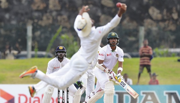 Bangladeshi batsman Soumya Sarkar (right) watches as Dinesh Chandimal of Sri Lanka drops a catch during the fourth day of the opening Test  in Galle yesterday. (AFP)