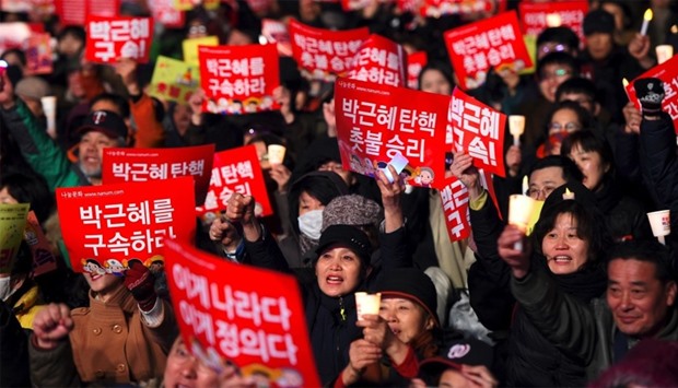 South Korean demonstrators hold up red banners reading 'Park Geun-Hye impeachment'