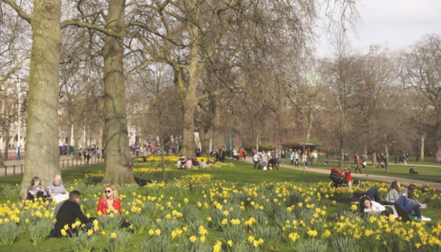 People relax among daffodils at St James Park in London yesterday.