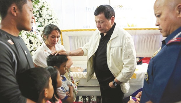 President Rodrigo Duterte comforts the children of the late Police Officer 1 Rholly Benelayo in a wake for the slain policeman at the Bansalan town hall in Davao del Sur.