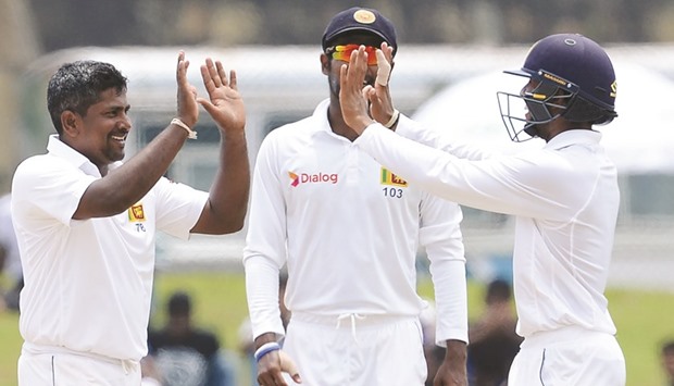 Sri Lankan cricketer Rangana Herath (L) celebrates with his teammates after he dismissed Bangladeshu2019s Taskin Ahmed during the final day of the first Test in Galle yesterday.