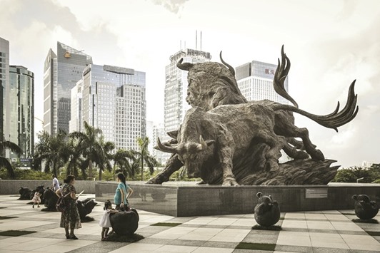 People stand in front of a sculpture of bulls at the entrance to the Shenzhen Stock Exchange building. Chinau2019s move to open its derivatives market to foreign bond investors could help counter outflows but lingering concerns about capital controls are keeping offshore investors cautious.