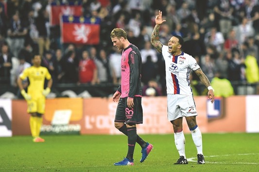 Lyonu2019s forward Memphis Depay (right) celebrates after scoring a goal as Toulouseu2019s Ola Toivonen looks on during the French Ligue 1 match in Lyon. (AFP)