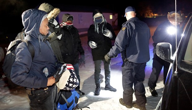Refugees that walked along railway tracks from the United States to enter Canada are detained by the Royal Canadian Mounted Police at Emerson, Manitoba, Canada.