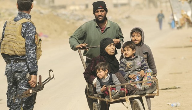 Displaced people flee their homes, while Iraqi forces battle with Islamic State militants, in western Mosul yesterday.