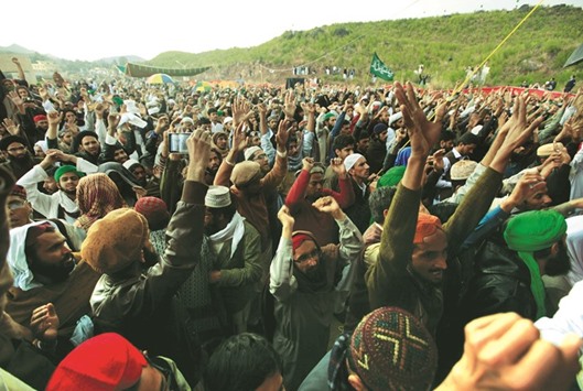 People chant slogans during a gathering to mark the anniversary of Mumtaz Qadri death next to the shrine built over his grave outside Islamabad yesterday.