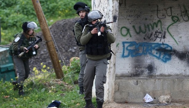 An Israeli policeman aims his weapon