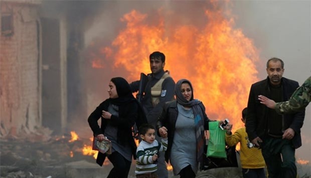 Survivors flee after a blast in Kabul on Monday.
