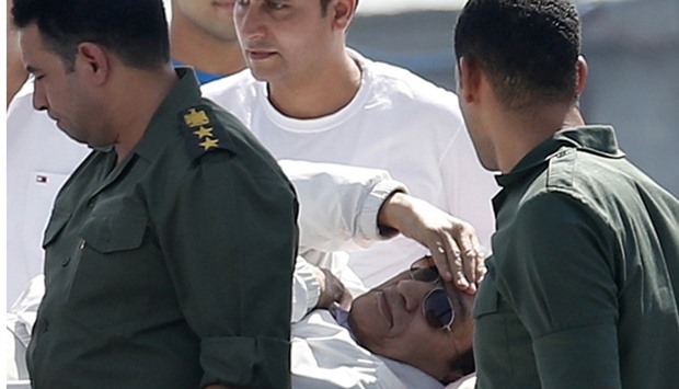 Egypt's former president Hosni Mubarak touches his head as he is transported back to a military hospital after a court hearing in the southern suburb of Maadi, on the outskirts of Cairo, August 25, 2013.