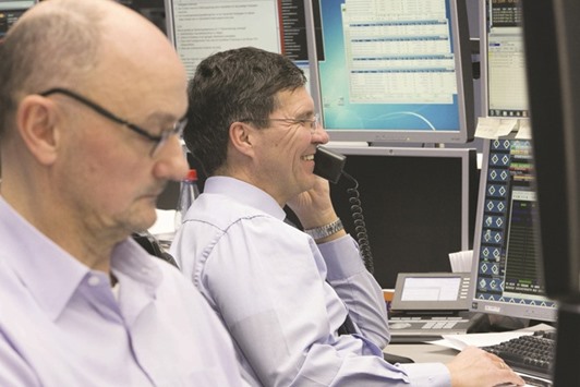 Traders monitor data at the Frankfurt Stock Exchange. The DAX 30 closed up 0.2% to 11,990.03 points yesterday.