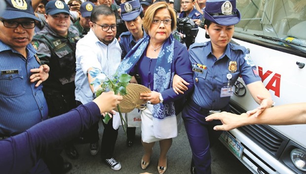 Police escort Leila De Lima, a senator detained on drug charges, on her way to a local court to face an obstruction of justice complaint in Quezon city, Metro Manila, yesterday.
