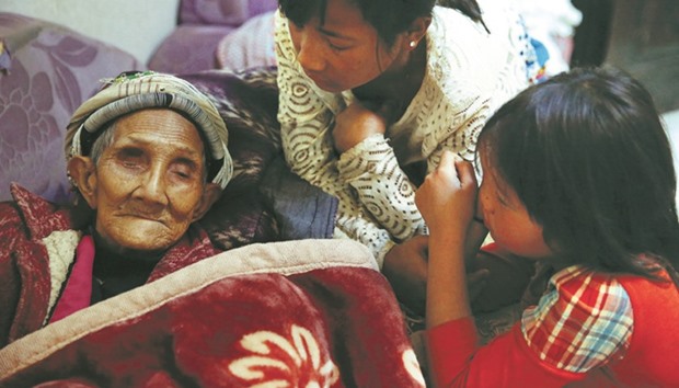 Refugees who fled fighting in neighbouring Myanmar talk to a 96-year-old family member of the house of a relative in the village of Baiyan near Nansan in the Yunnan province, China.