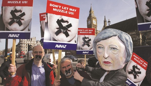 A demonstrator wearing a mask depicting Prime Minister Theresa May takes part in a Brexit protest outside the Parliament in London yesterday afternoon.