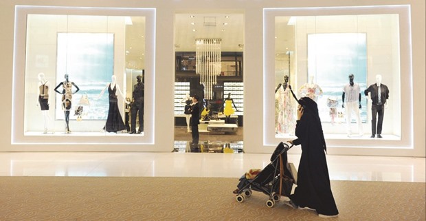 A woman passes a store in a shopping mall in Dubai. In a survey of over 500 participants representing businesses operating in the GCC region, Ernst and Young found that 50% of them have not started any preparations to implement VAT and only 29% have studied some of the new VAT provisions.