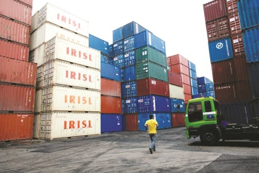 A truck driver walks past a stack of Islamic Republic of Iran Shipping Lines containers at a depot in northern Singapore. IRISL has held meetings in London to discuss a possible listing on the London Stock Exchange, but has so far been thwarted by US sanctions that still scare banks off Iranian business.