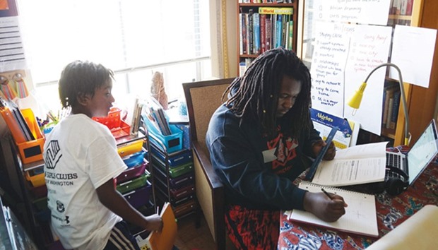 Two children do their homework at home in Washington, DC.
